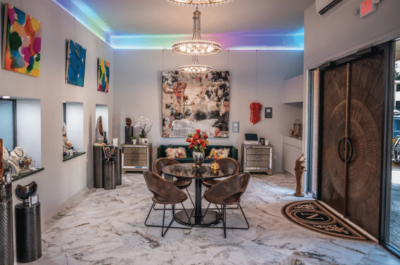 retail space (top photo) is just inside the entrance of House of NeVille. Jewelry, hats, candles and paintings are some of the items available for purchase. As guests
venture farther into the building, Harvison, Kent and Jenkins hope everyone finds something that fits their interests. The gallery space features works by about a
dozen local artists and has places for guests to sit and enjoy the art. The art will rotate out every three to four months based on a theme. Colored lights run along the
floor and ceiling to help set a calming mood.