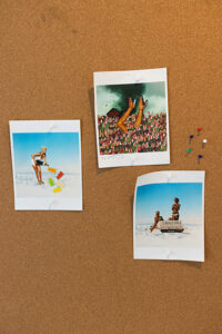 Three photos at the beach are pinned to a cork board.