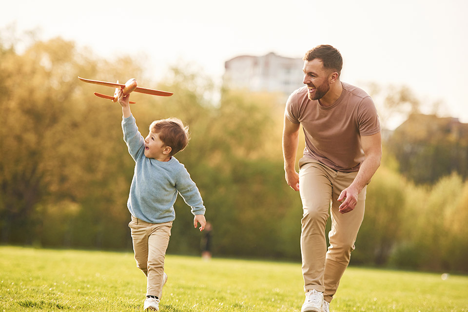 A dad and son play in a field